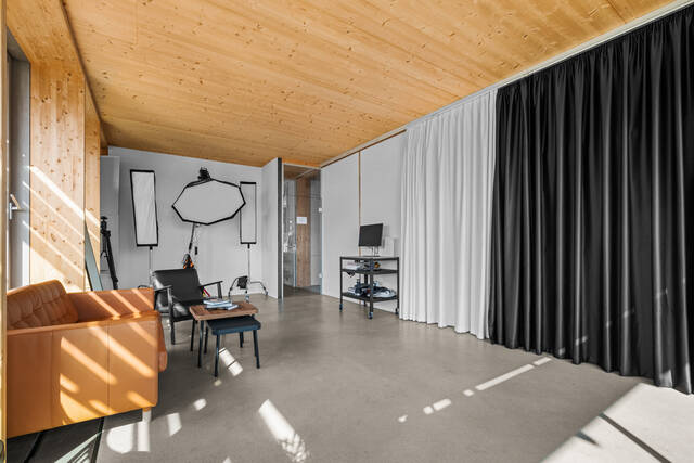 Softbox rangées contre le mur blanc, coin salon et chariot de visionnage