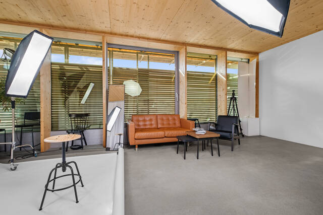Coin salon et mur de fenêtres, stores à moitié fermés